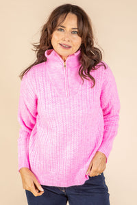 Woman wearing a pink pullover with a zipper on a beige background