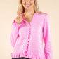 Model wearing pink cardigan on beige background