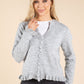 Model wearing grey cardigan on beige background