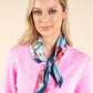Woman wearing a colorful scarf around her neck against a beige background