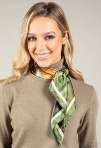 woman wearing a knit top and a green neck scarf