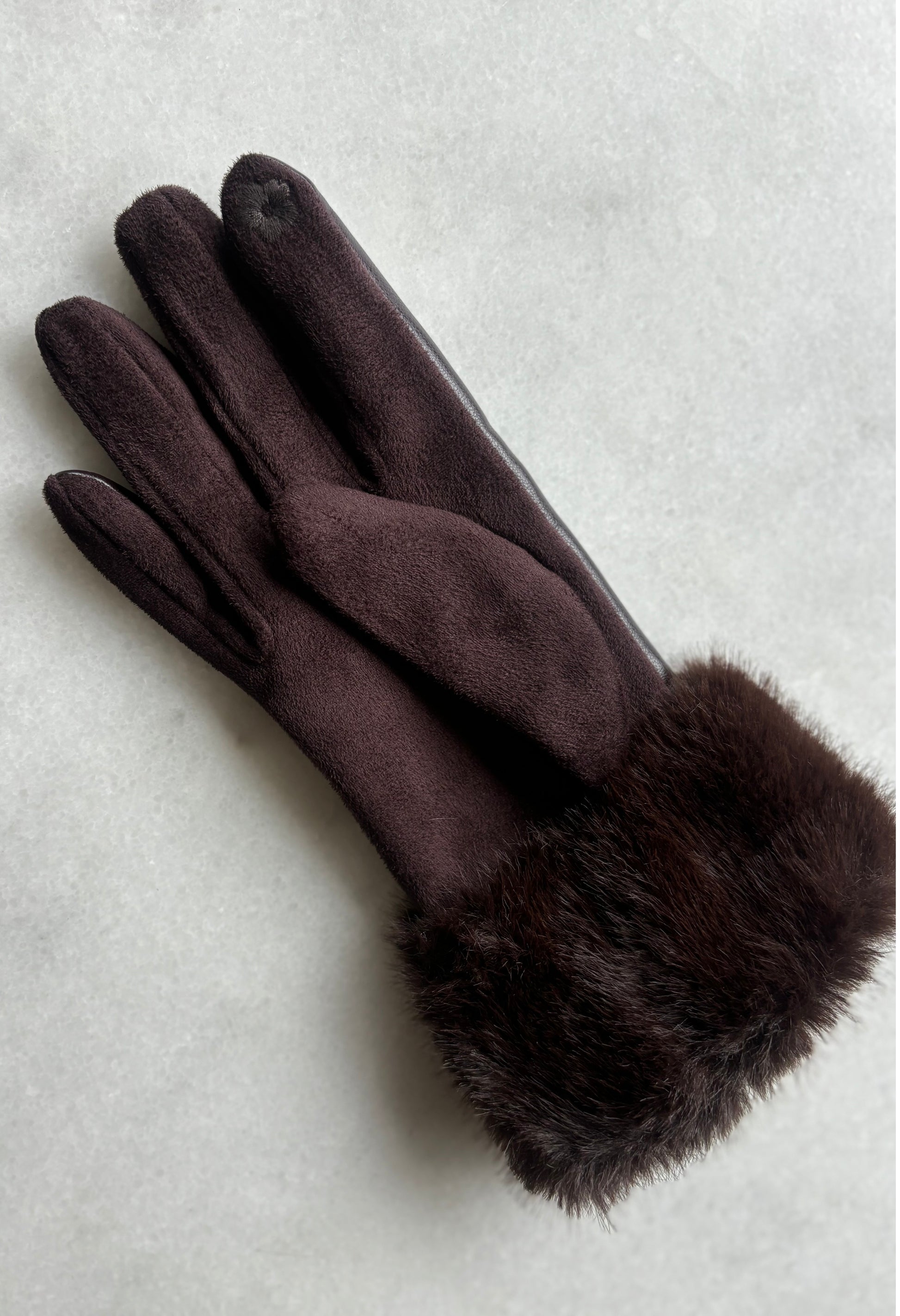 Dark brown gloves with fur cuffs on a light gray background