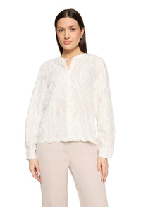 Woman wearing a white lace blouse and beige pants on a white background