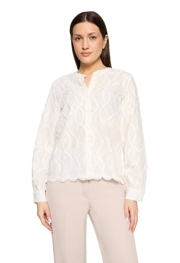 Woman wearing a white lace blouse and beige pants on a white background