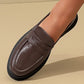 Brown loafer shoe on a beige background