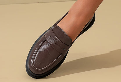 Brown loafer shoe on a beige background