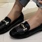 faux snake effect loafer with gold buckle on a models foot with a white background