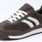 Brown sneaker with white stripes on a white background