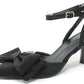 Black high-heeled shoes with bow detail on a white background