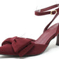 Maroon high-heeled shoe with bow detail on a white background