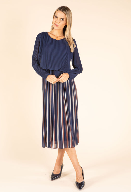 Woman wearing a burgundy top and striped skirt holding a matching handbag on a beige background