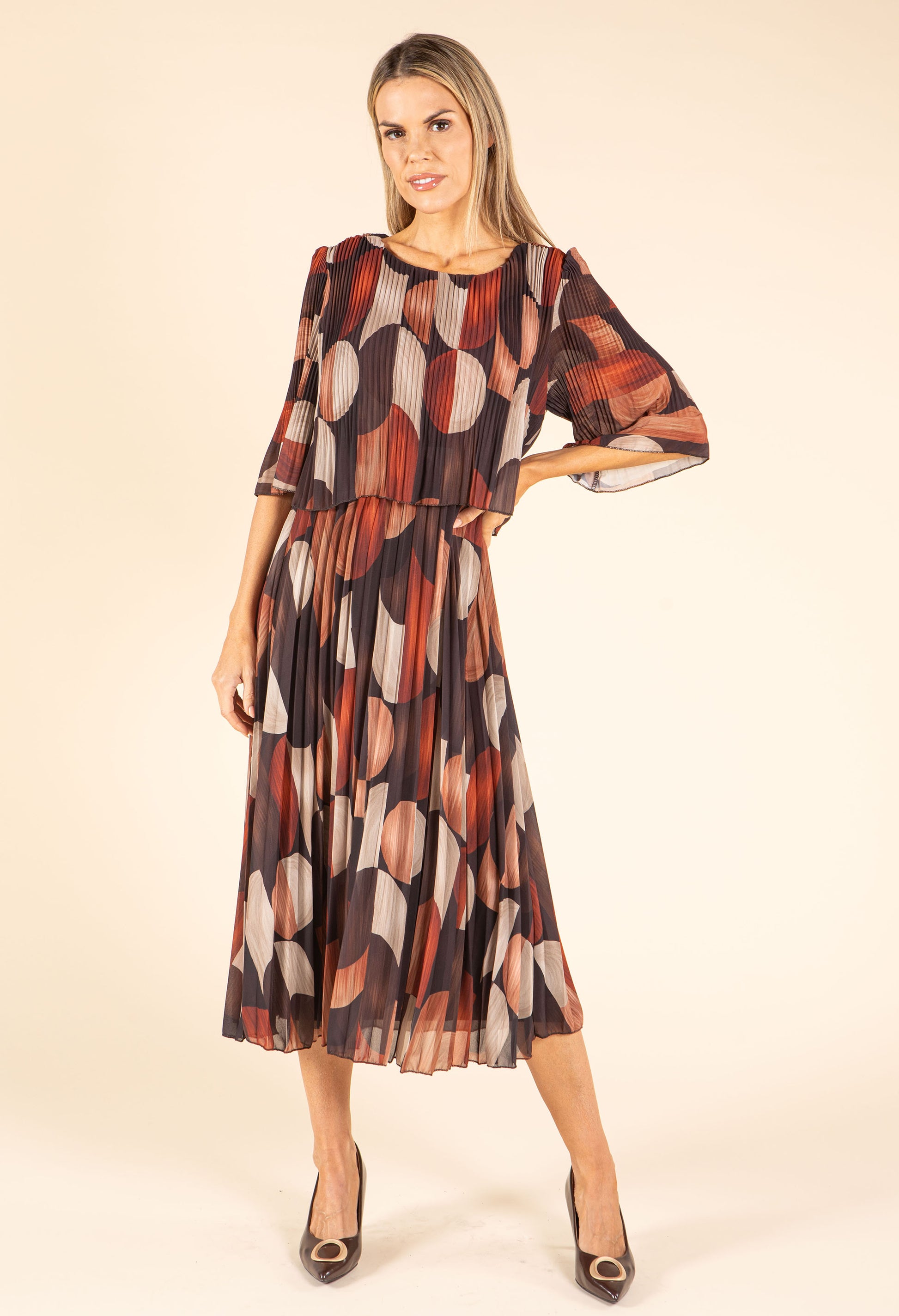 Woman wearing a patterned dress on a beige background