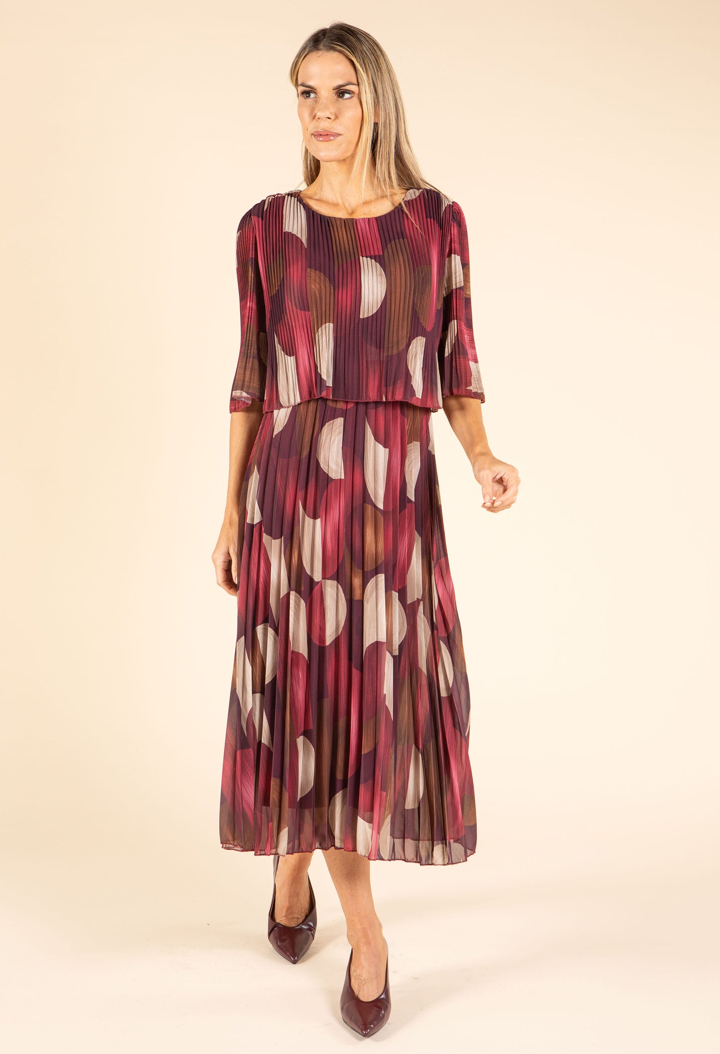 Woman wearing a patterned dress on a beige background