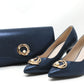 Navy blue shoes and matching clutch with gold accents on a white background