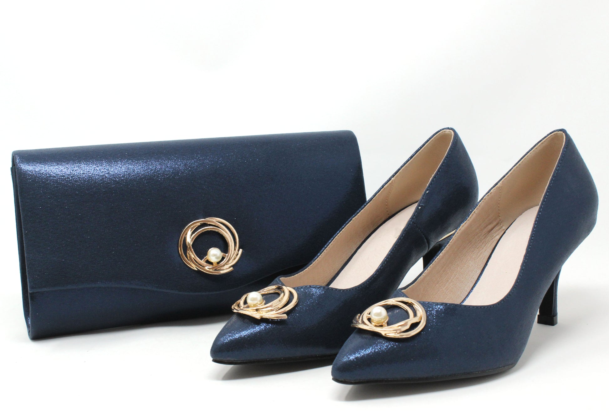 Navy blue shoes and matching clutch with gold accents on a white background