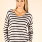 Woman wearing a black and white striped sweater on a beige background