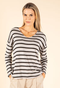 Woman wearing a black and white striped sweater on a beige background