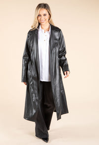 model in black leather coat and white shirt on beige background