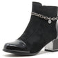 Black ankle boot with chain detail on a white background