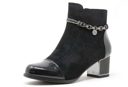 Black ankle boot with chain detail on a white background
