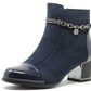 Navy blue ankle boot with a metallic chain detail on a white background