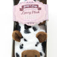 Cow-themed plush feeties in packaging with a visible brand label.