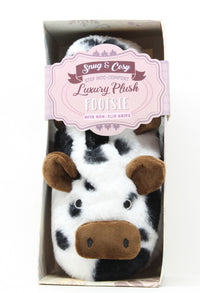 Cow-themed plush feeties in packaging with a visible brand label.