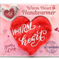 Heart-shaped handwarmer with 'Warm Heart' text on a pink packaging background