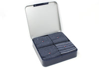 Set of gray socks in a metal box on a white background