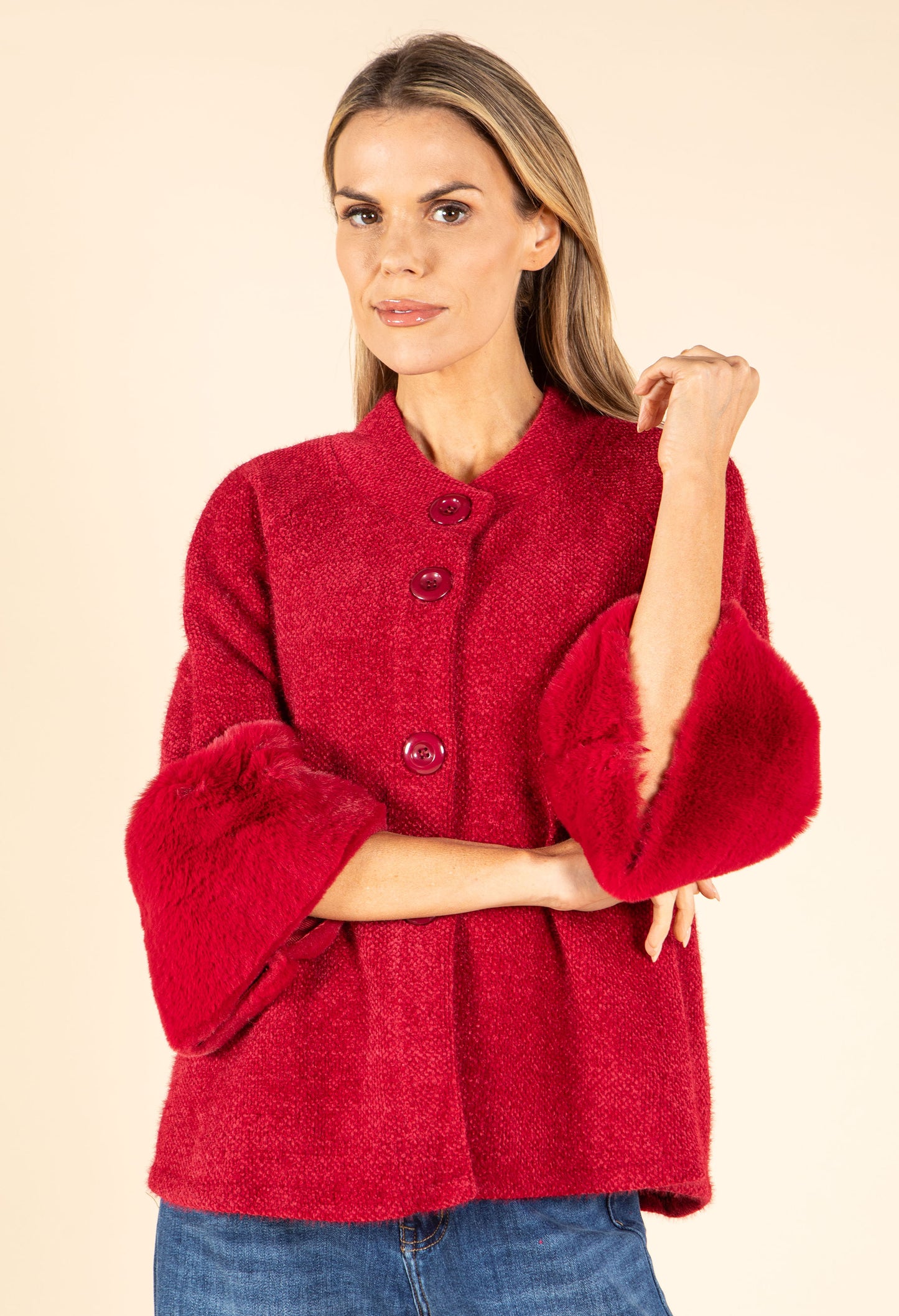 Woman wearing a red textured jacket on a beige background