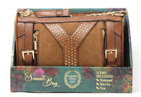 Brown studded handbag with gold accents on a decorative box packaging.