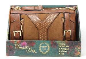 Brown studded handbag with gold accents on a decorative box packaging.