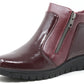 Burgundy patent leather ankle boot with a zipper on a white background