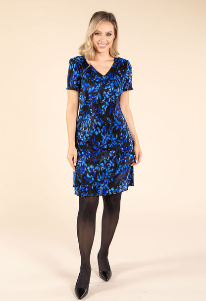 Woman wearing a blue floral dress on a beige background