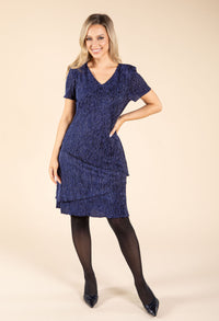 Woman wearing a blue dress on a beige background