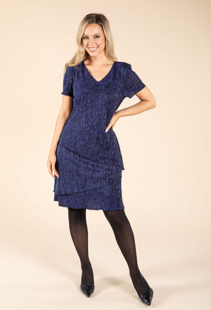 Woman wearing a blue dress on a beige background