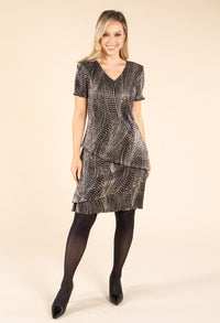 model wearing black and gold dress on beige background