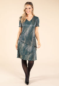 model wearing green and gold dress on beige background