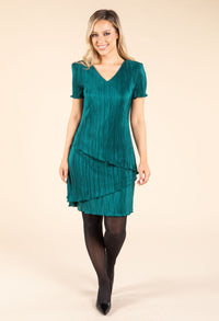 Woman wearing a green dress on a beige background