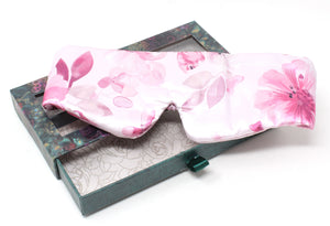 Floral-patterned sleep mask on a decorative box with a white background