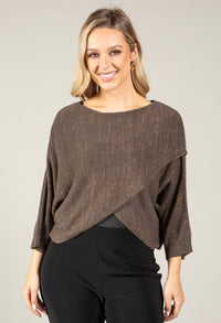Woman wearing a brown knit top with a plain background