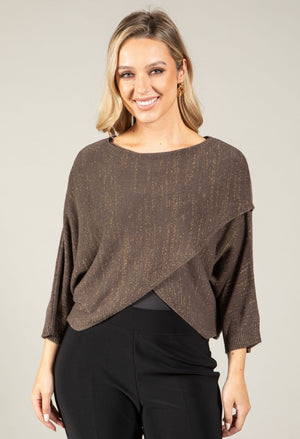 Woman wearing a brown knit top with a plain background
