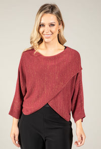 Woman wearing a maroon sweater with a plain background