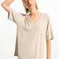 Woman wearing a beige oversized t-shirt on a white background