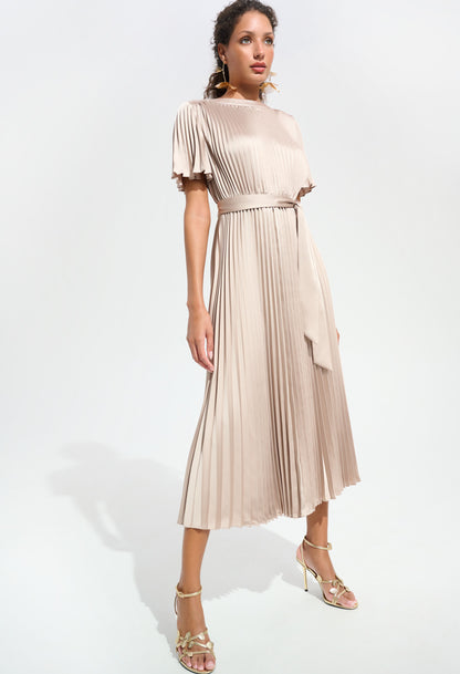 Woman wearing a beige pleated dress on a white background