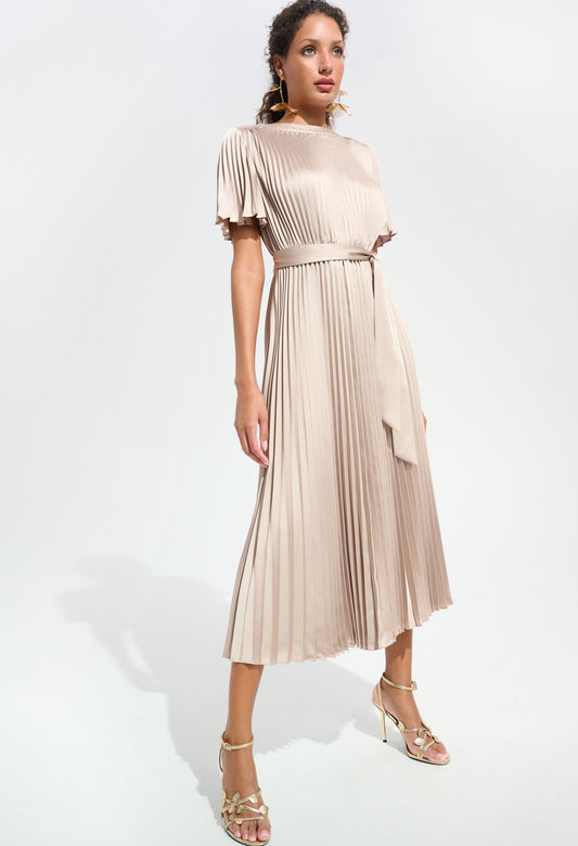 Woman wearing a beige pleated dress on a white background