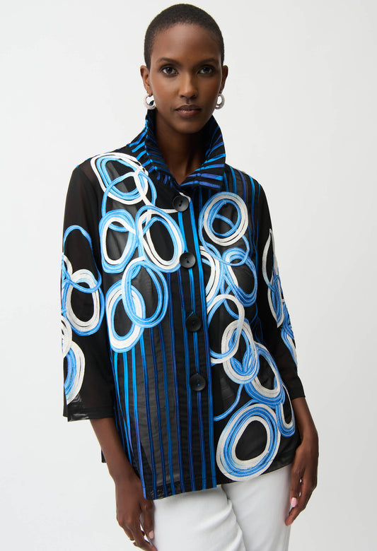 Woman wearing a black jacket with blue and white circular patterns on a white background