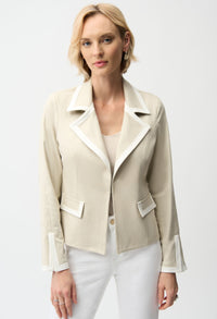 Woman wearing a beige blazer with white trim on a white background