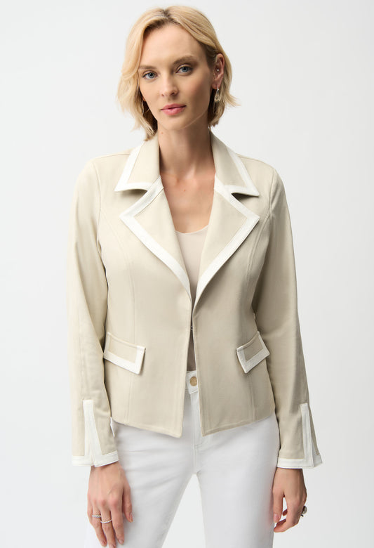 Woman wearing a beige blazer with white trim on a white background
