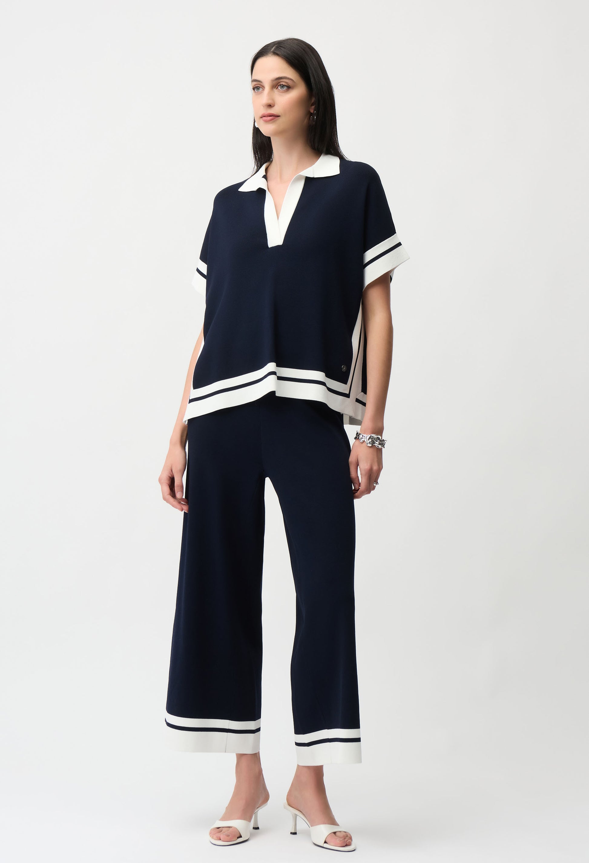 woman wearing a navy pullover with white trim and matching trousers